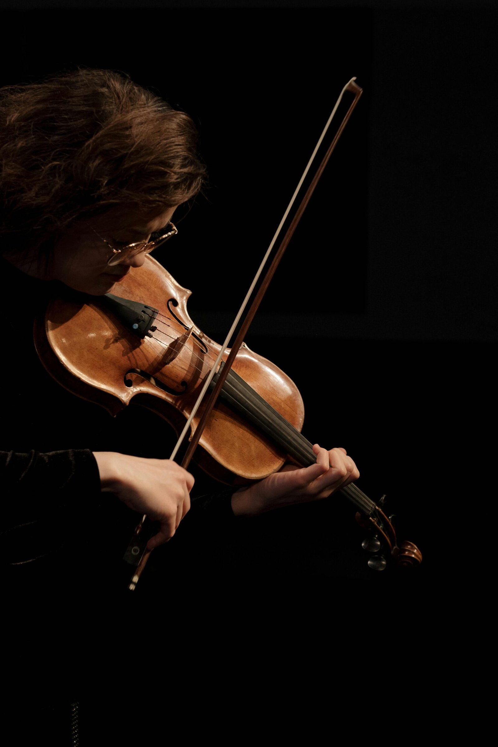 A professional violinist performing passionately under soft lighting, creating an elegant musical ambiance.